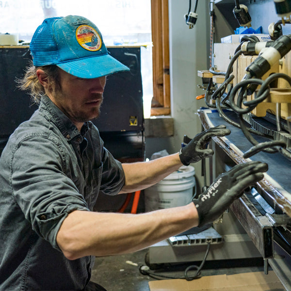 A Wagner Custom Skis employee presses a pair of skis at the factory.