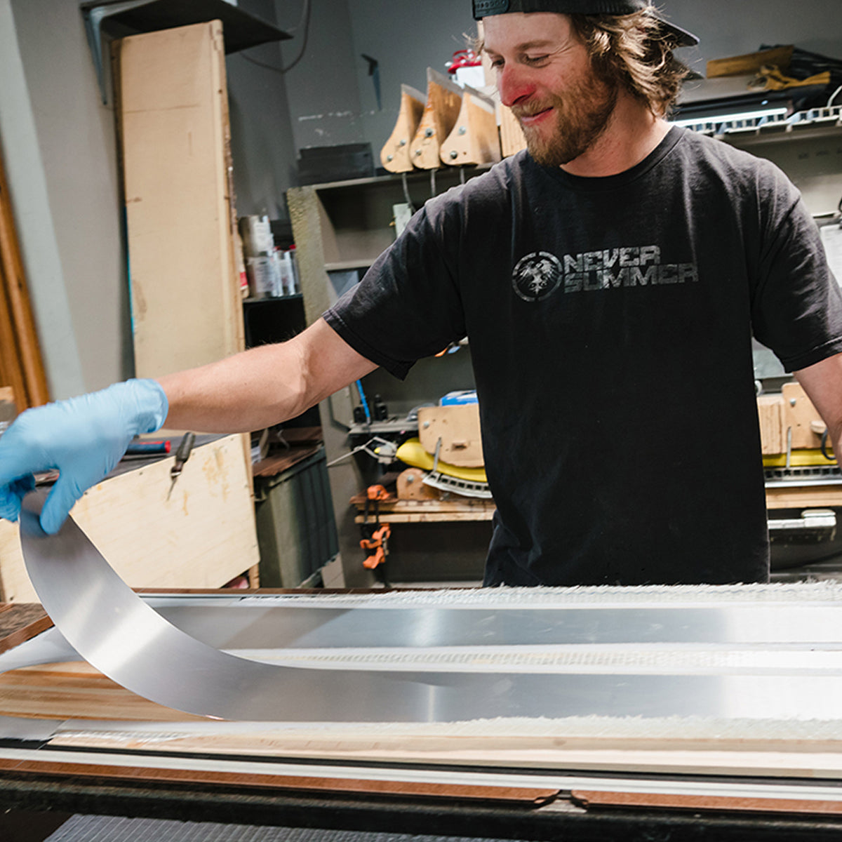 Tyler Campbell presses a pair of skis at the Wagner Custom Ski Factory