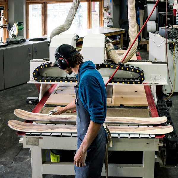 A Wagner Custom Skis employee checks a pair of custom wood veneer skis.